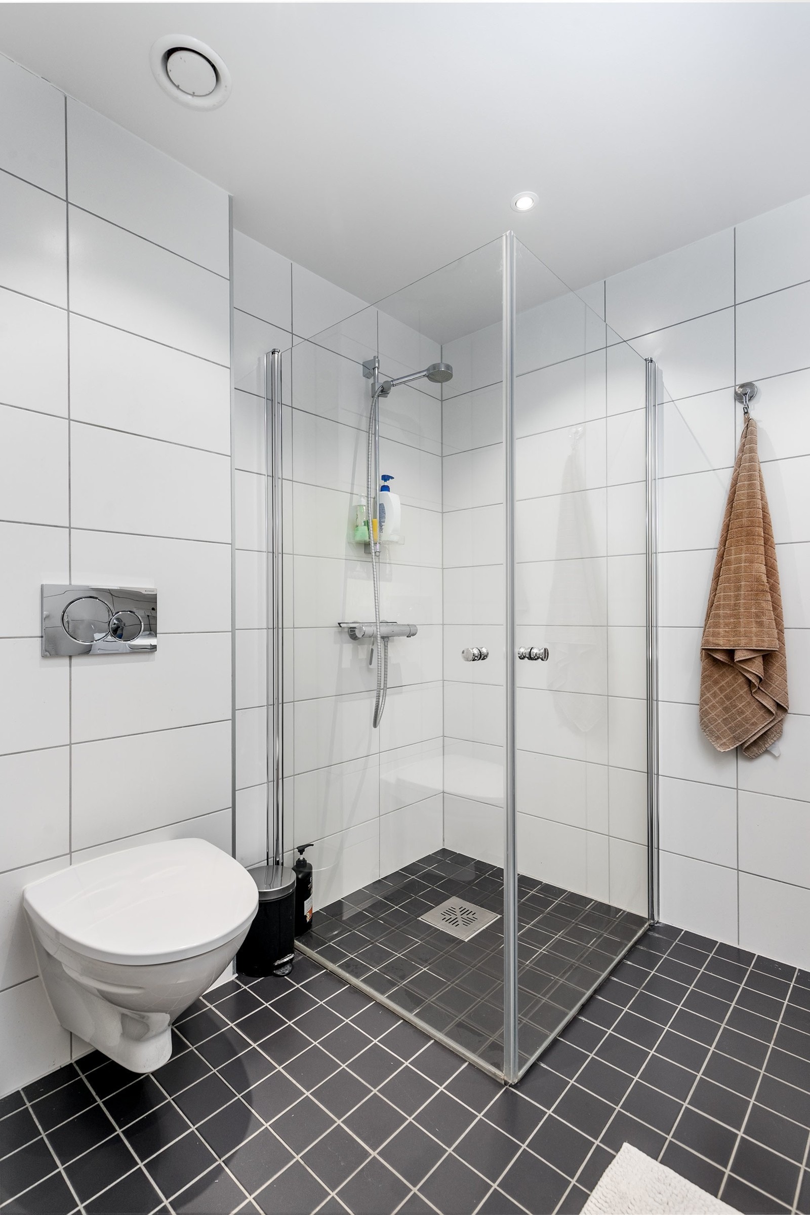 Videre har badet et separat dusjhjørne med innfellbare glassdører. Rommet har opplegg og plass for vaskemaskin. Himlingen er lyssatt med downlights.